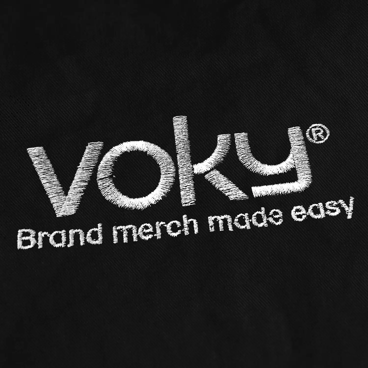 Vit broderad Voky-logga på svart tyg